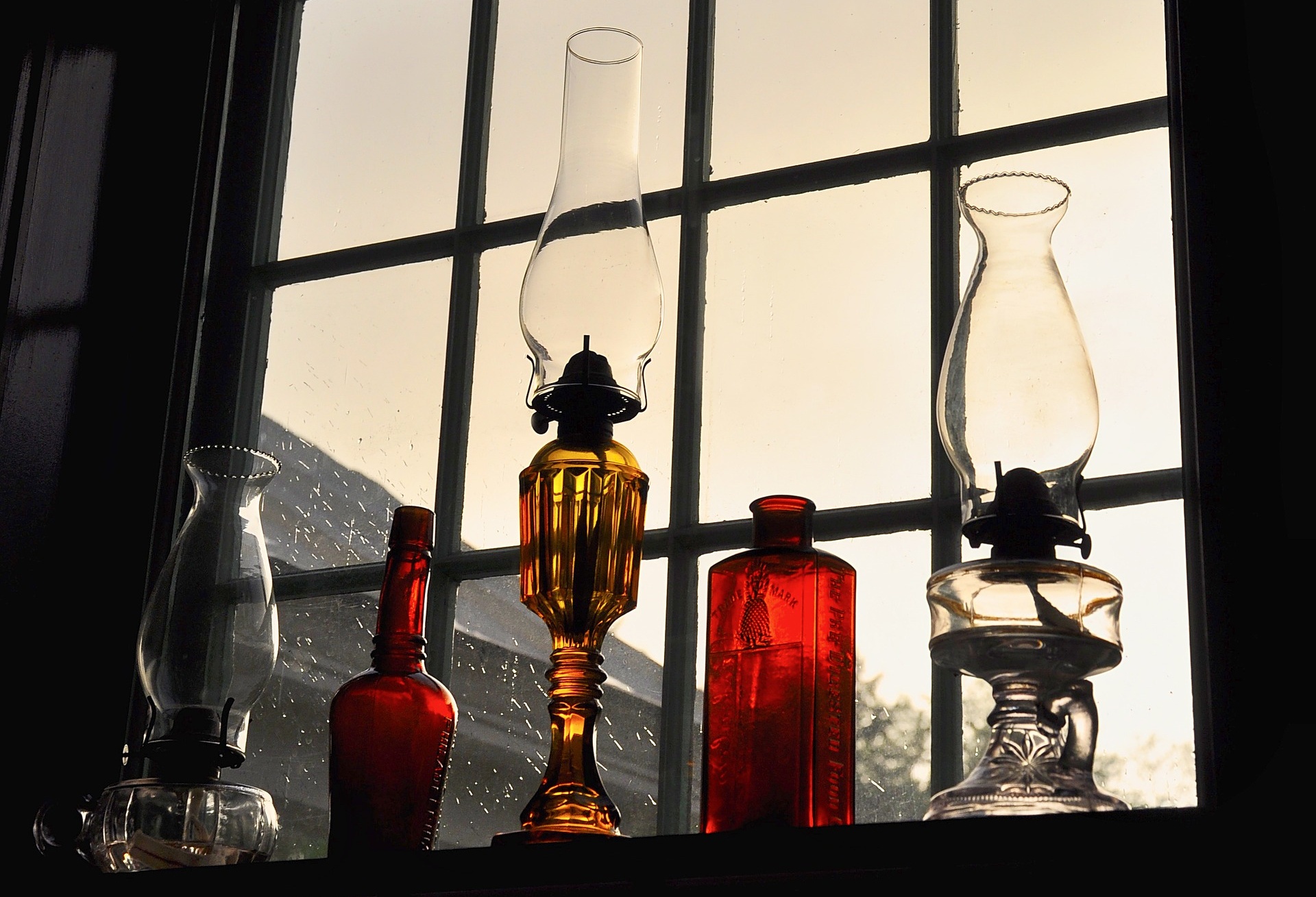 Zdjęcie przedstawiające lampy stojące pod oknem, ustawione jedna za drugą.